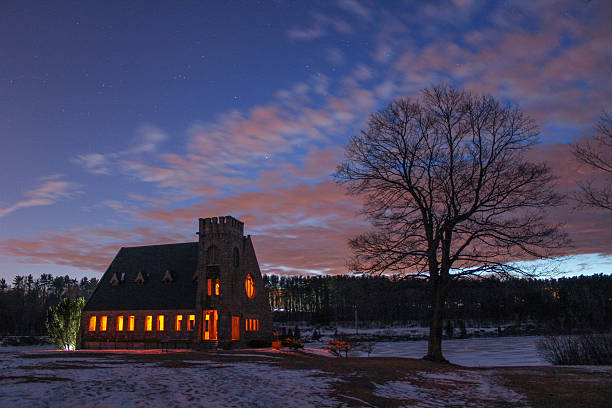 istock Winter sunset with lighted church with snow cover. 533345135