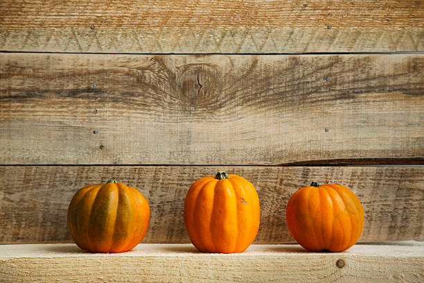 istock Three Pumpkins on Old  Wooden Background 533347445