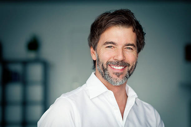 Close Up Of A Mature Man Smiling At The Camera stock photo