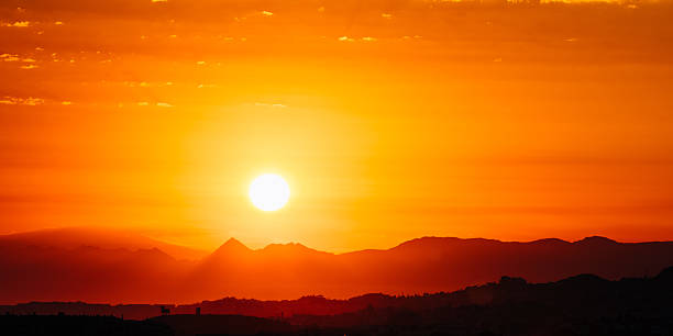 Amazing Sunset Sunrise With Sun Over Dark Mountain Ground Silhouette Panorama of Amazing Sunset Sunrise With Sun Over Dark Mountain Ground Silhouette orange sunset stock pictures, royalty-free photos & images