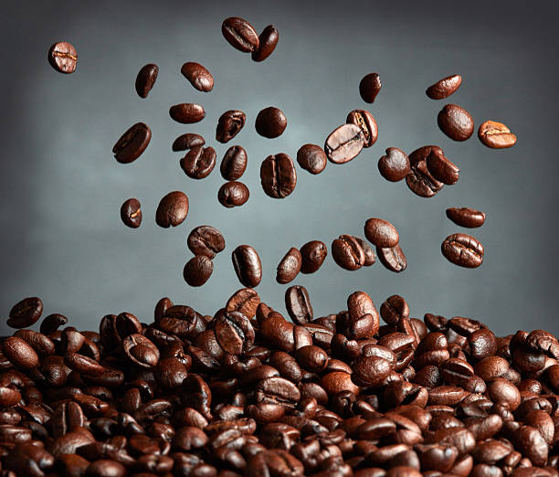 vuelo granos de café sobre fondo oscuro - caffeine selective focus indoors studio shot fotografías e imágenes de stock