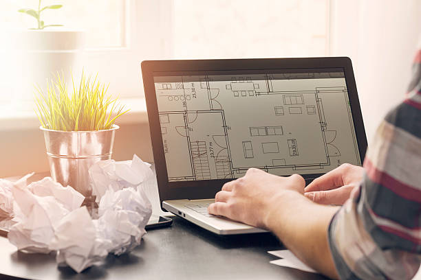 istock architect, interior designer working on laptop with floor plans 533349758
