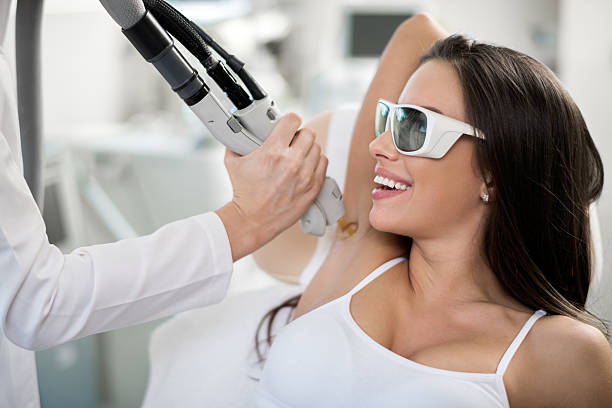 Woman on epilation treatment Young woman is having her armpit hair removed with medical laser procedure. laser hair removal stock pictures, royalty-free photos  images