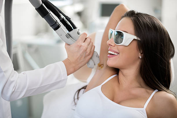 Woman on epilation treatment Young woman is having her armpit hair removed with medical laser procedure. medical laser photos stock pictures, royalty-free photos & images