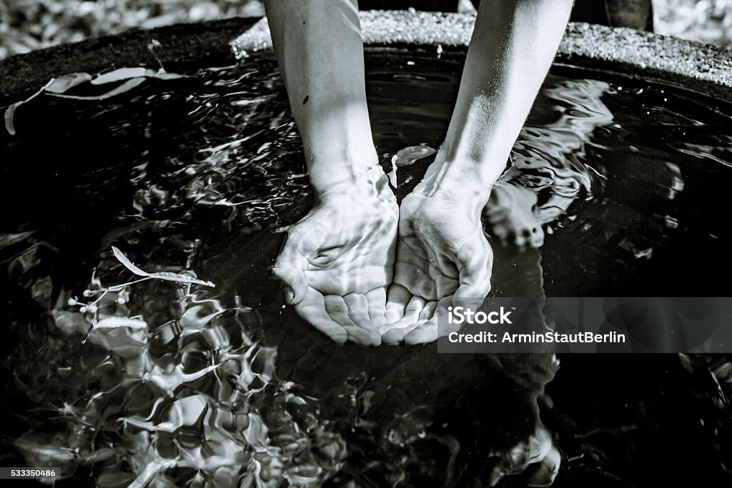 Holding water from a well  in cupped hands Holding water from a well  in cupped hands, black and white shot Fountain Stock Photo