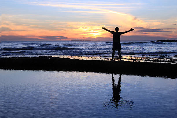 männliche silhouette bei sonnenuntergang. - god freedom arms raised high angle view stock-fotos und bilder