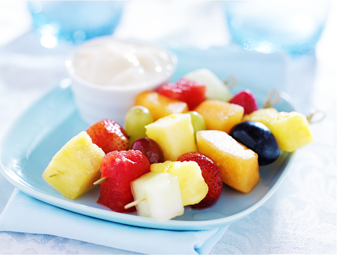 children's fruit kabob with vanilla yogurt dip on blue plate