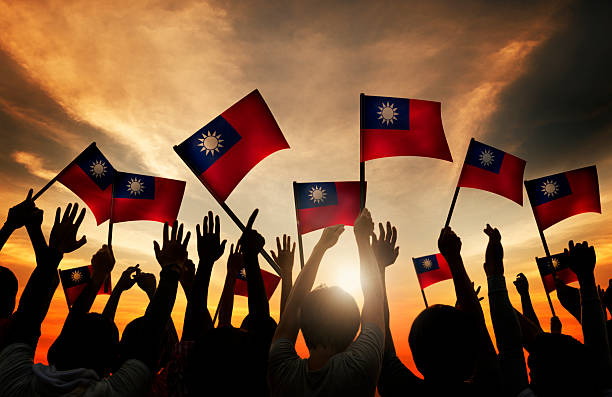 istock Group of People Waving Taiwanese Flags in Back Lit 533375287