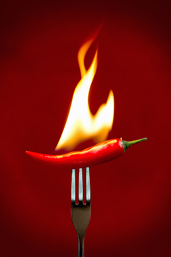 Red hot chili peper burning on fork.