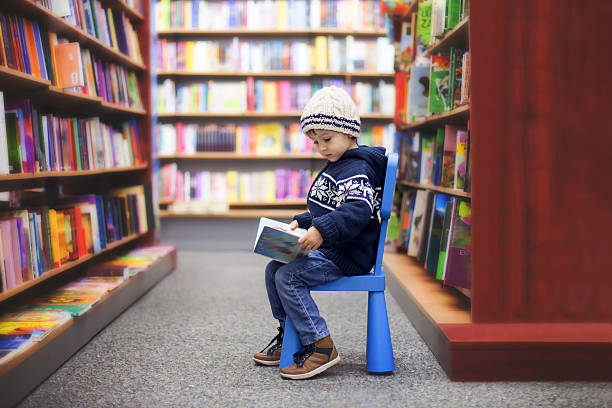 istock Adorable little boy, sitting in a book store 533380063