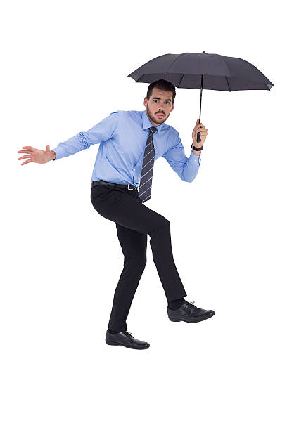 istock Anxious businessman under umbrella balancing 533397237