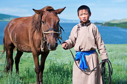 Young Mongolian horseback rider. Lake in the background.http://bem.2be.pl/IS/mongolia_380.jpg