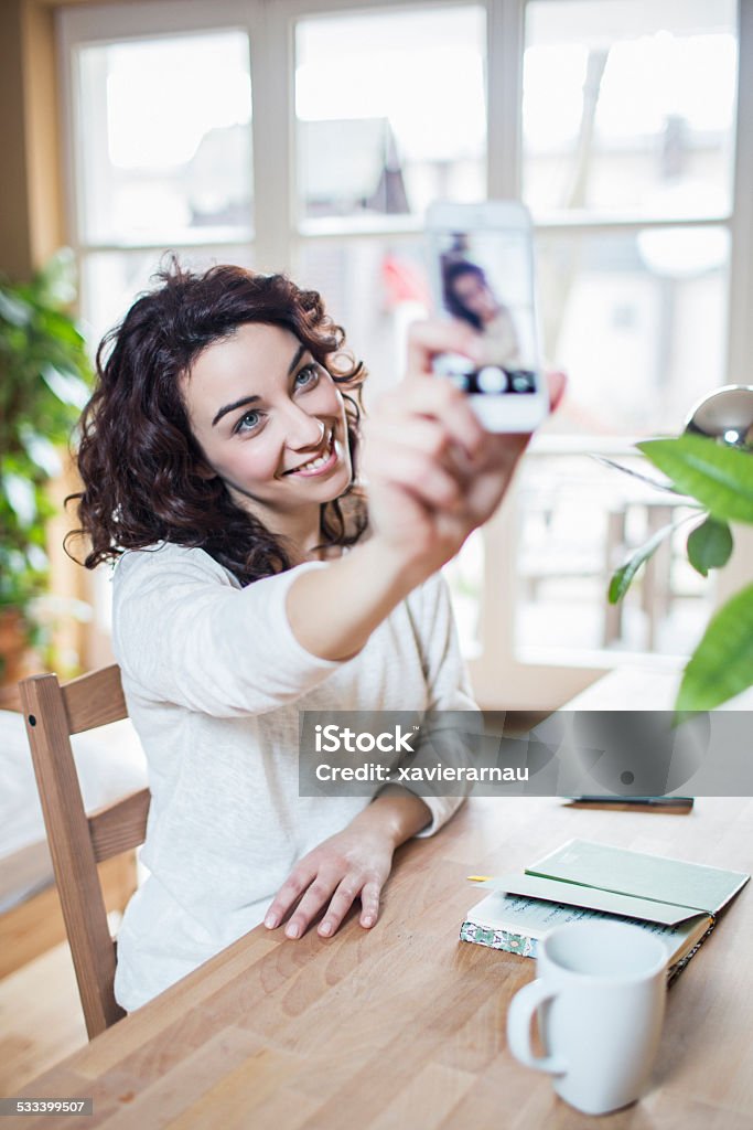 Selfie to send Woman taking a selfie with the mobile phone. 2015 Stock Photo