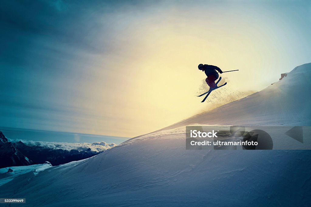 Extreme   Freestyle snow skier  jumping   Off pist  back country skiing Off pist,  back country skiing.  Extreme skiing. Silhouette. Freestyle skier jumping in the air. Beautiful nature in a sunset time. Powder snow. Alps mountains snowy landscape. Cortina d’Ampezzo, Italy ski resort. Queen of the Dolomites. Skiing Stock Photo