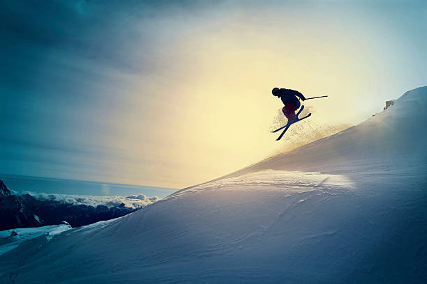 Extreme   Freestyle snow skier  jumping   Off pist  back country skiing Off pist,  back country skiing.  Extreme skiing. Silhouette. Freestyle skier jumping in the air. Beautiful nature in a sunset time. Powder snow. Alps mountains snowy landscape. Cortina d’Ampezzo, Italy ski resort. Queen of the Dolomites. extreme skiing stock pictures, royalty-free photos & images