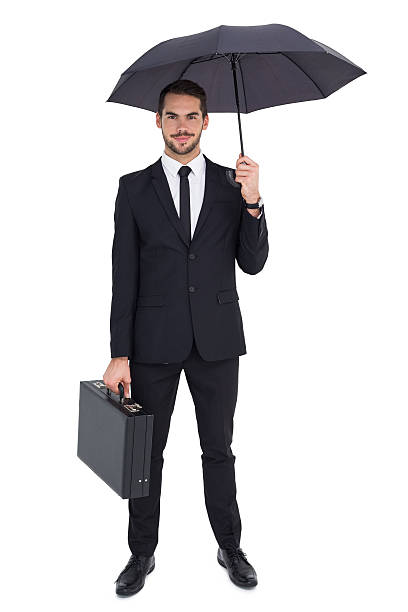 istock Smiling businessman under umbrella while holding briefcase 533400033