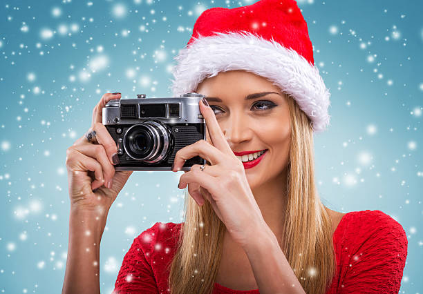 istock Beautiful santa woman holding camera, snowfall background 533401163