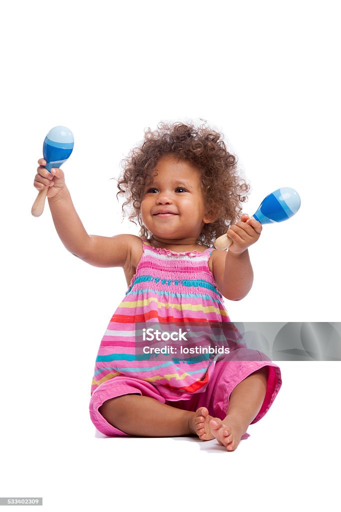 Biracial Baby Girl/ Toddler Waving Her Maracus Isoltated On White A happy biracial baby girl/ toddler waving her maracas isolated on a white background. Toddler Stock Photo