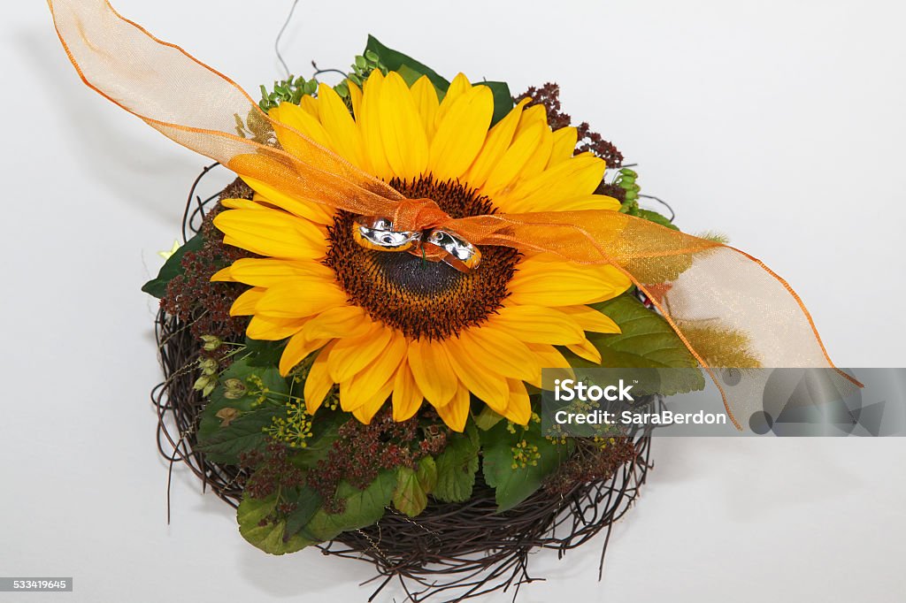 Wedding rings Wedding rings on bouquet with single yellow sunflower on white background 2015 Stock Photo
