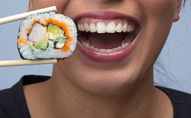 istock woman eating sushi 533419893