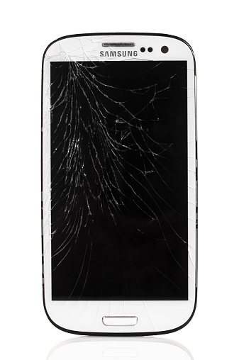 Alanya, Turkey - April 15, 2014: A front view of a cracked Samsung Galaxy smartphone isolated on white background, displaying the blank screen. Samsung Galaxy is a touchscreen smart phone produced by Samsung Electronics.