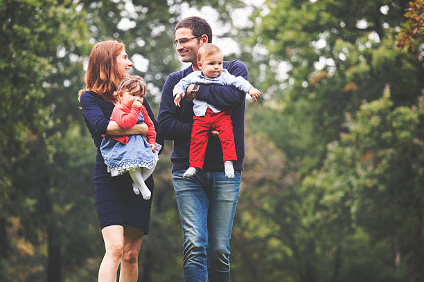 istock Happy parents walking in the park with twin babies 533425289