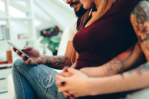 istock Young Tattooed Couple Using Smart Phone 533432110