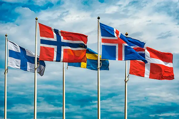 The flags of the countries of Scandinavia waving in the sky of a beautiful summer day.