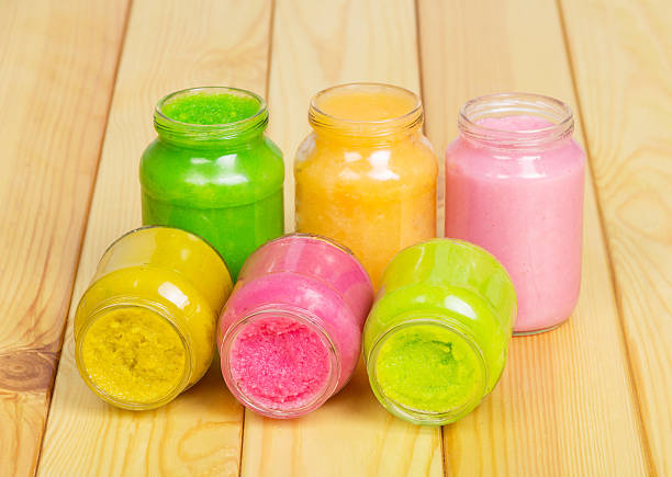 Different kinds  sauce in glass jars on background  light wood