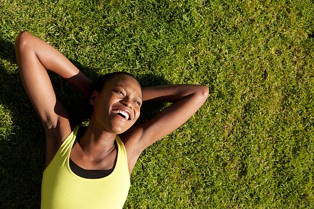 istock Happy young african woman resting on grass after workout 533434534