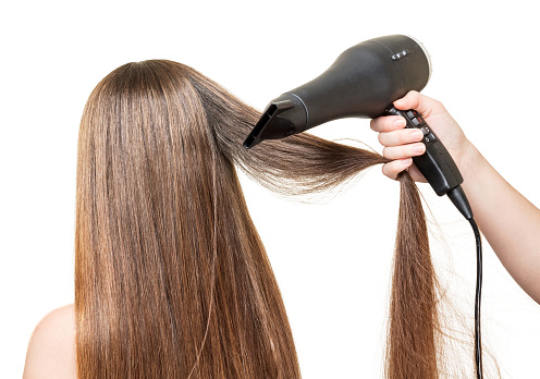 Long brown hair, and hair dryer in a hand isolated on white background.