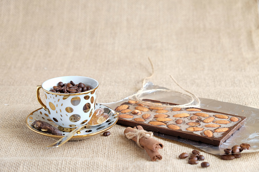 handmade chocolate with nuts on burlap background with cup on beans coffee