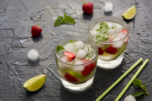 Refreshing summer cocktail with lime, strawberry and mint. Mojito cocktail, selective focus