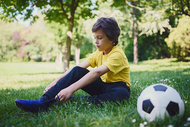 istock Young Soccer Boy Tying Shoes Preparing for Training 533438476