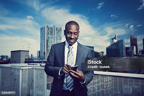 Businessman Using A Smart Phone On The Rooftop Stock Photo - Download Image Now - Businessman, Mobile Phone, Rooftop