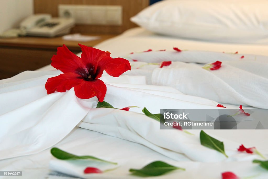 Decorated Hotel Bed Romantic Flower Petal Arrangement on a Hotel Bed. 2015 Stock Photo