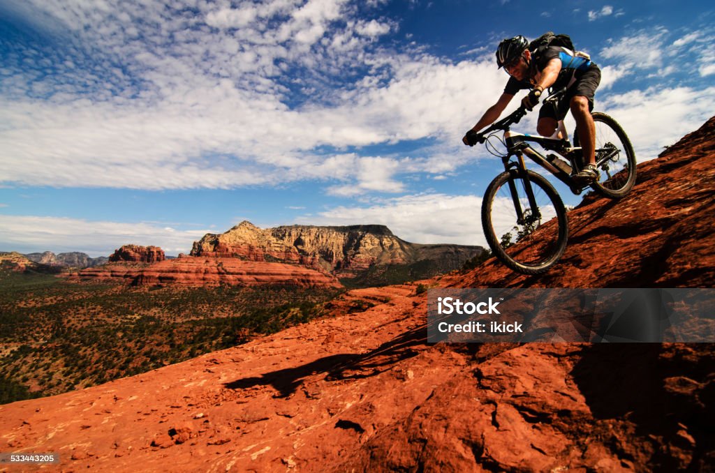 Mountain Biking on Slickrock Mountain biker going downhill on slickrock in Sedona, Arizona Mountain Biking Stock Photo