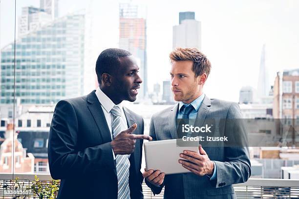 Business People Discussing Project On Digital Tablet Stock Photo - Download Image Now