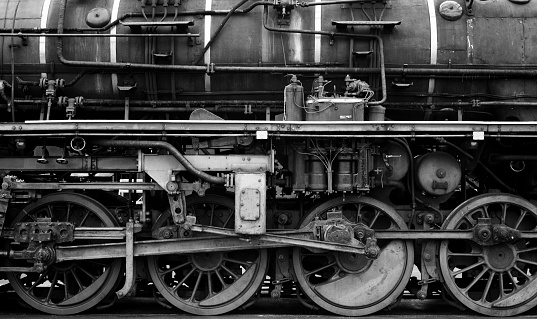 Old vintage steam locomotive wheels in black and white.