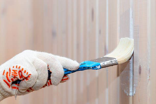istock Hand in glove paint the wooden wall protective paint 533445054