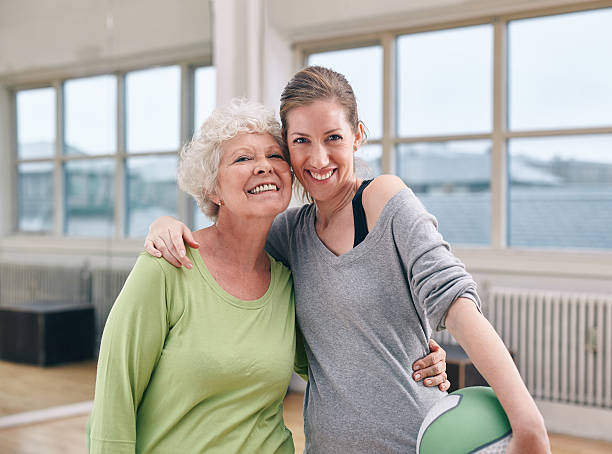istock Senior woman with her personal trainer at gym 533445327