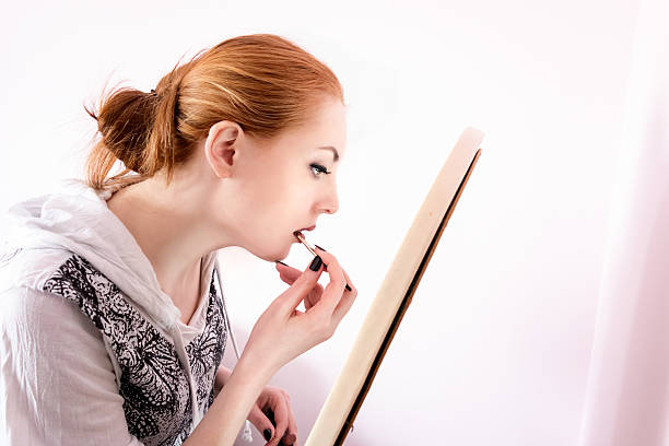 mulher colocando batom em - make up brush brushing make up cosmetics - fotografias e filmes do acervo