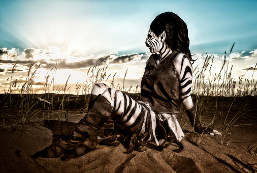 Lady Zebra Humanoid. Stripes galore as she takes up almost the entire frame with her beauty. pointed ears. Stripes. Black and White. Desert Sands Costume. And huge longe lashes. Texture applied. And Rainbow accents the sky in the background. Humanoid is looking off into the distance.