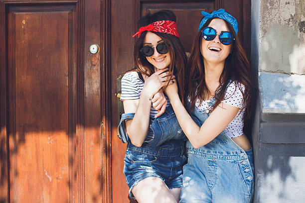 Brunette twins sisters hugging and laughing. Having fun. Copy space. stock photo
