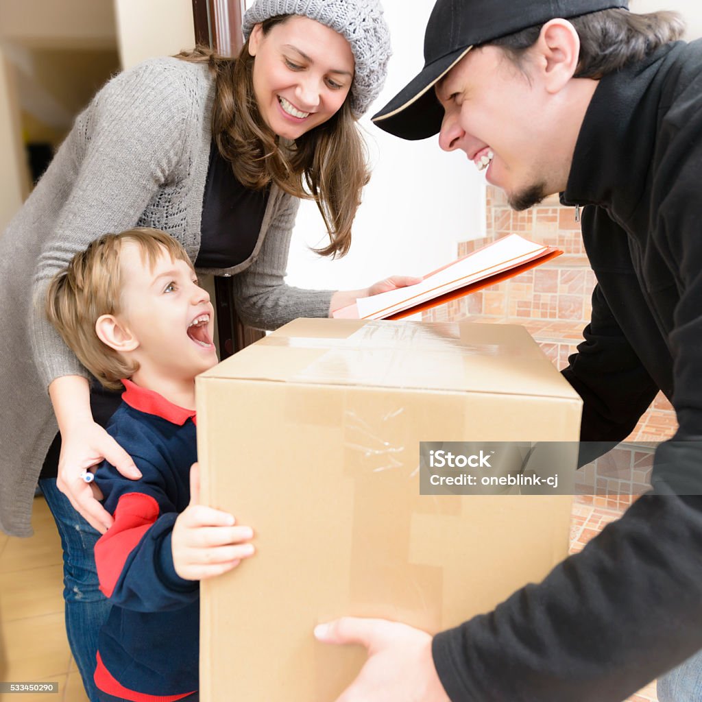 Courier Delivering a Package Courier Delivering a Package to a happy boy Child Stock Photo