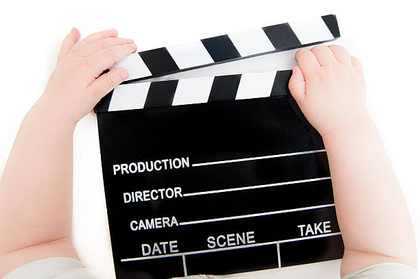 istock Movie clapper board with baby hands 533451248