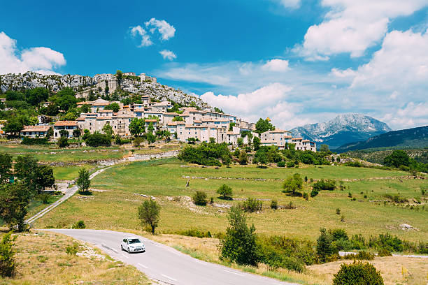 auto geht auf straße in der nähe von mittelalterlichen bergdorf dorf, trigance, frankreich - mountain mountain range landscape france stock-fotos und bilder