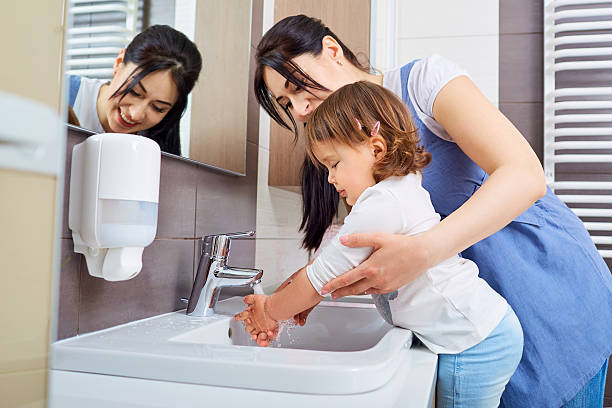 kid se laver les mains avec la mère dans la salle de bains. - water jet photos et images de collection