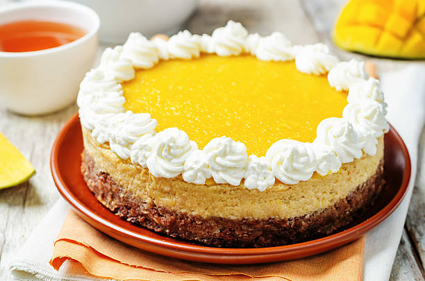 istock mango cheese cake decorated with whipped cream and mango puree 533453974