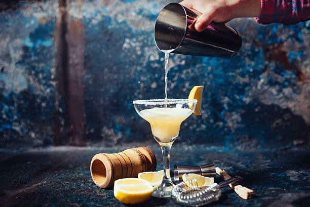 bartender vertiendo margarita de lima fresca en un vaso de lujo en el restaurante - mixing table fotografías e imágenes de stock